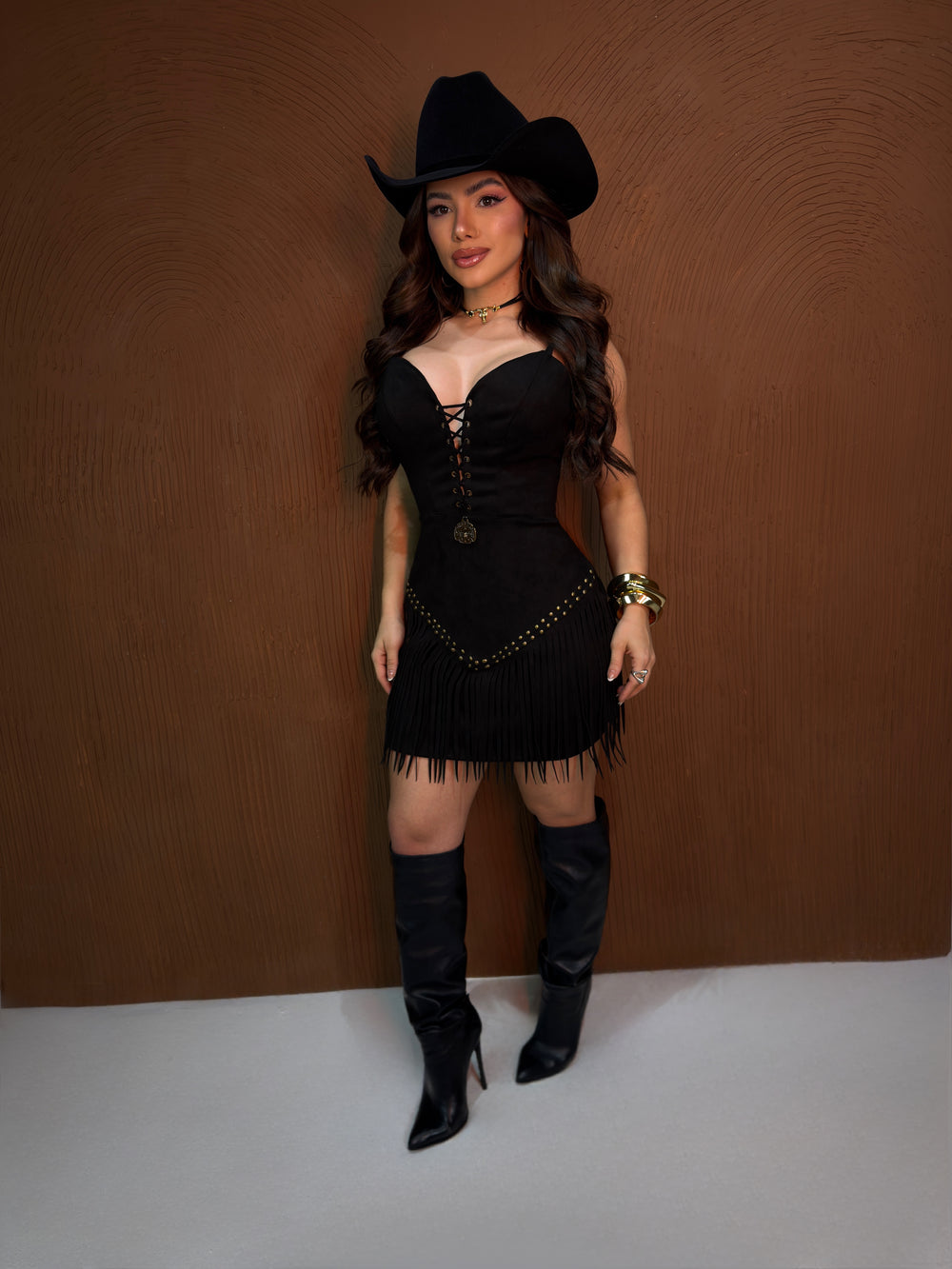 Vestido Rodeio Luxo | Suede Premium com Decote Ilhós, Tachas Ouro Velho e Barra de Franjas